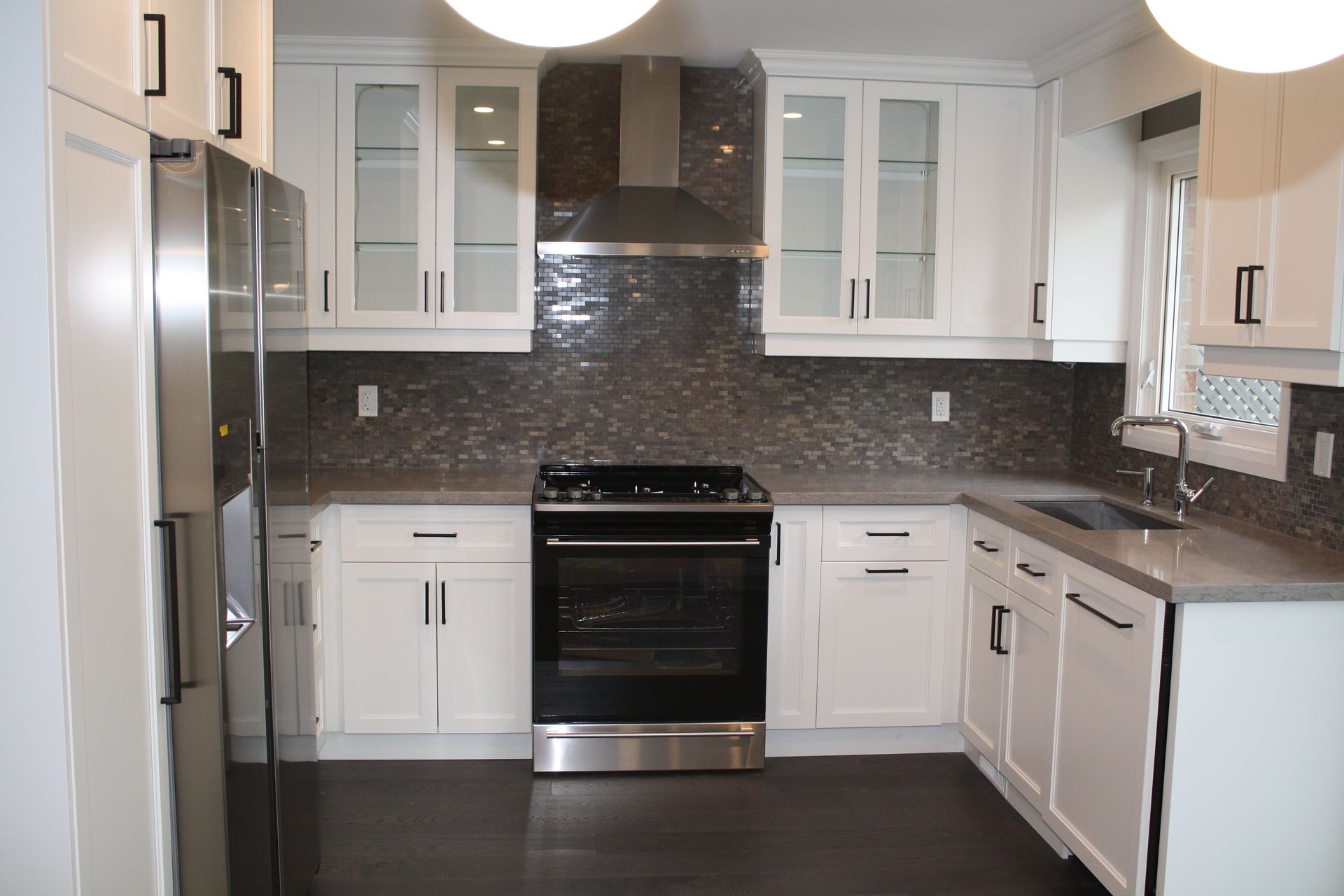 A kitchen with white cabinets and stainless steel appliances