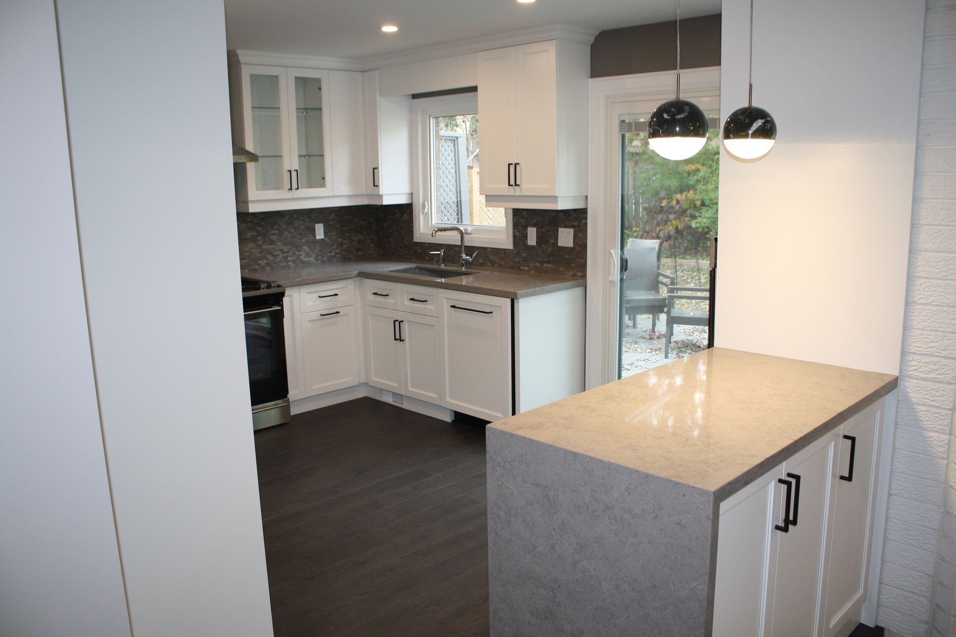 A kitchen with white cabinets and granite counter tops