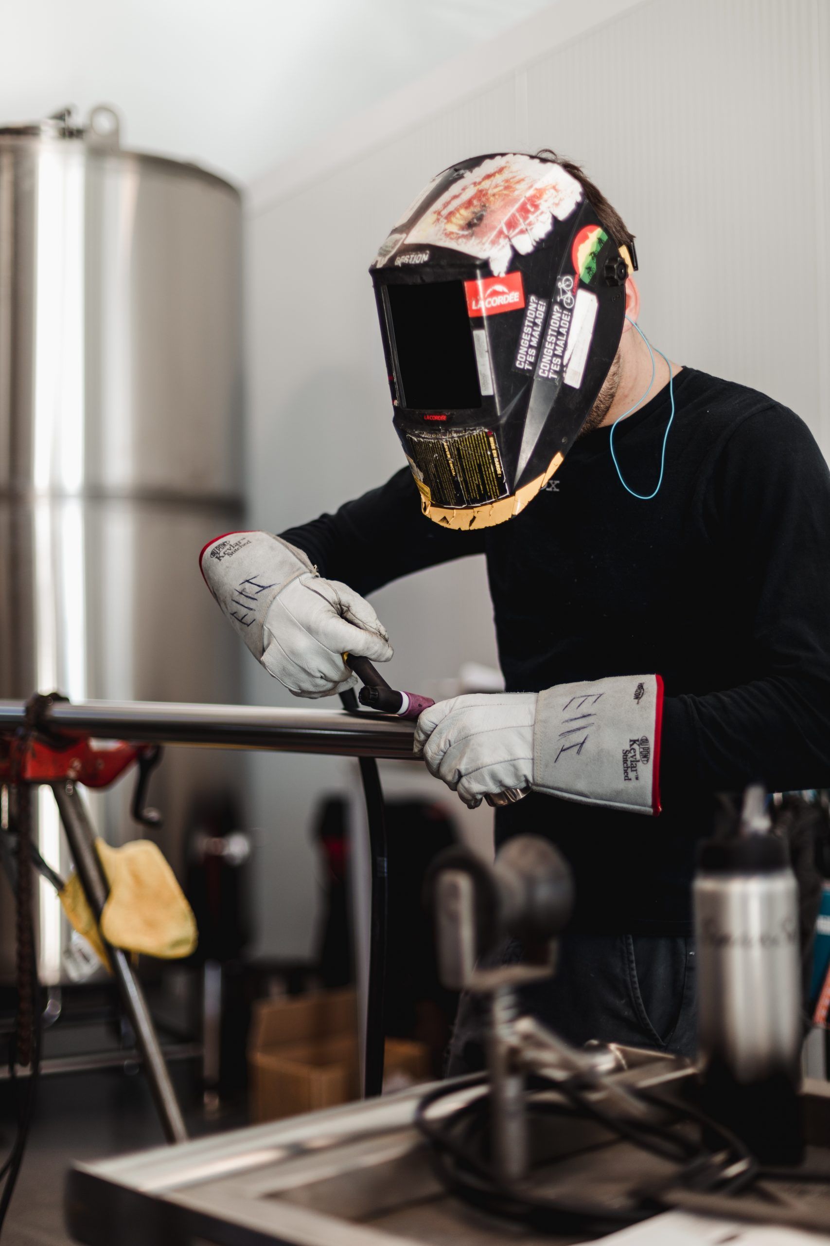 Un homme portant un casque de soudage soude un morceau de métal.