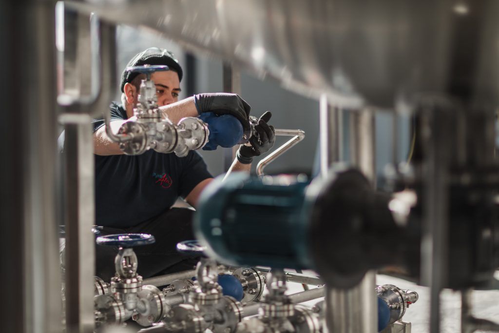 Un homme travaille sur une machine dans une usine.