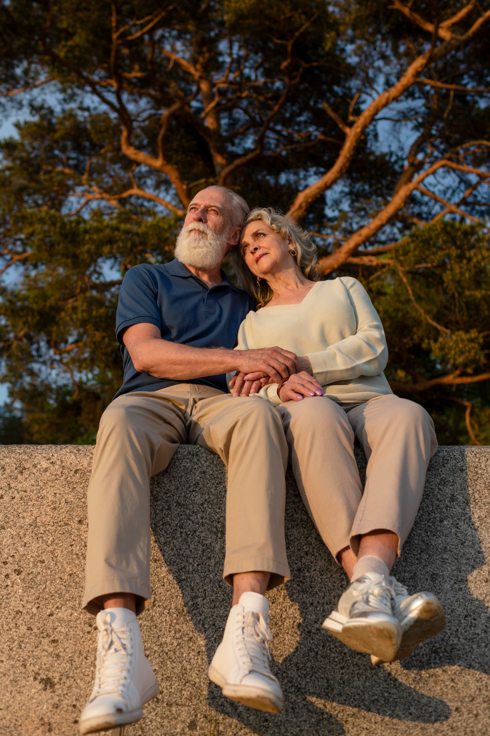 A living room with a couch , chairs , ottoman and a mirror