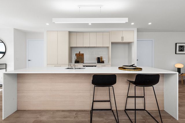 A kitchen with a large island and two stools
