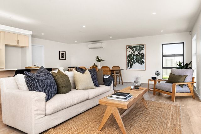 A living room with a white couch and a wooden coffee table.