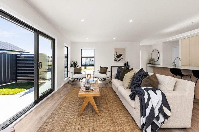 A living room with a couch , chairs , table and sliding glass doors.