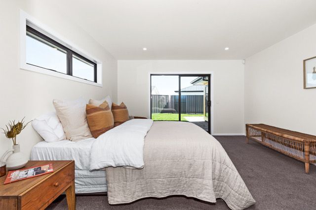 A bedroom with a large bed and a sliding glass door.
