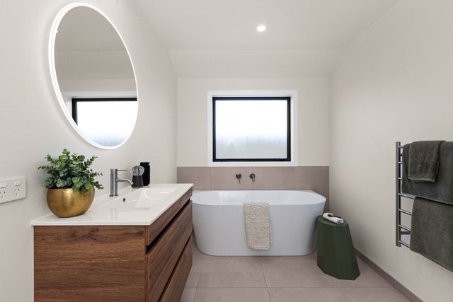 A bathroom with a tub , sink and mirror