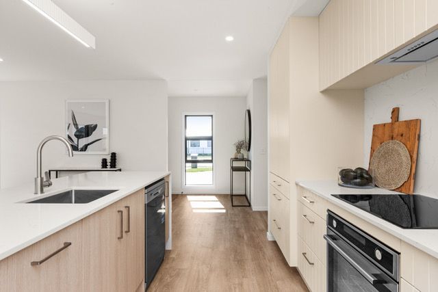 A kitchen with a sink , stove , and dishwasher.