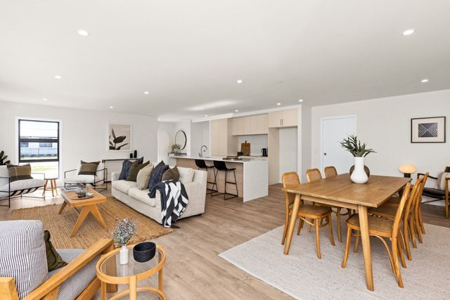 A living room and dining room in a house with a table and chairs.