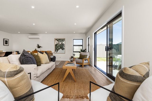 A living room with a couch , chairs , coffee table and sliding glass doors.