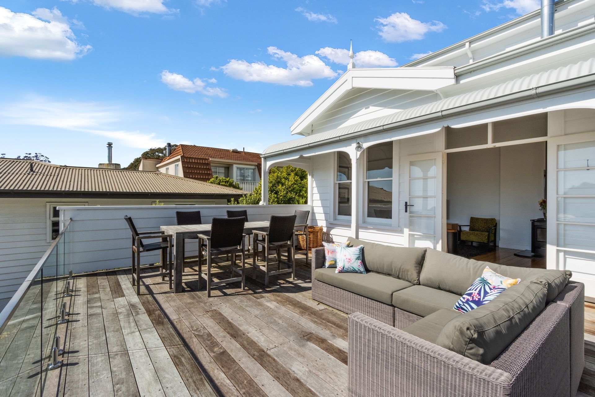 A large deck with a couch , table and chairs on it.