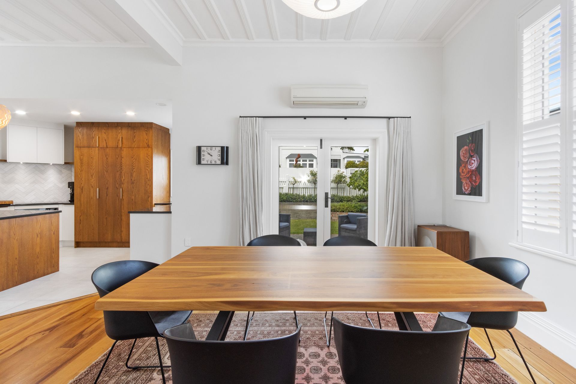 A dining room with a wooden table and chairs.