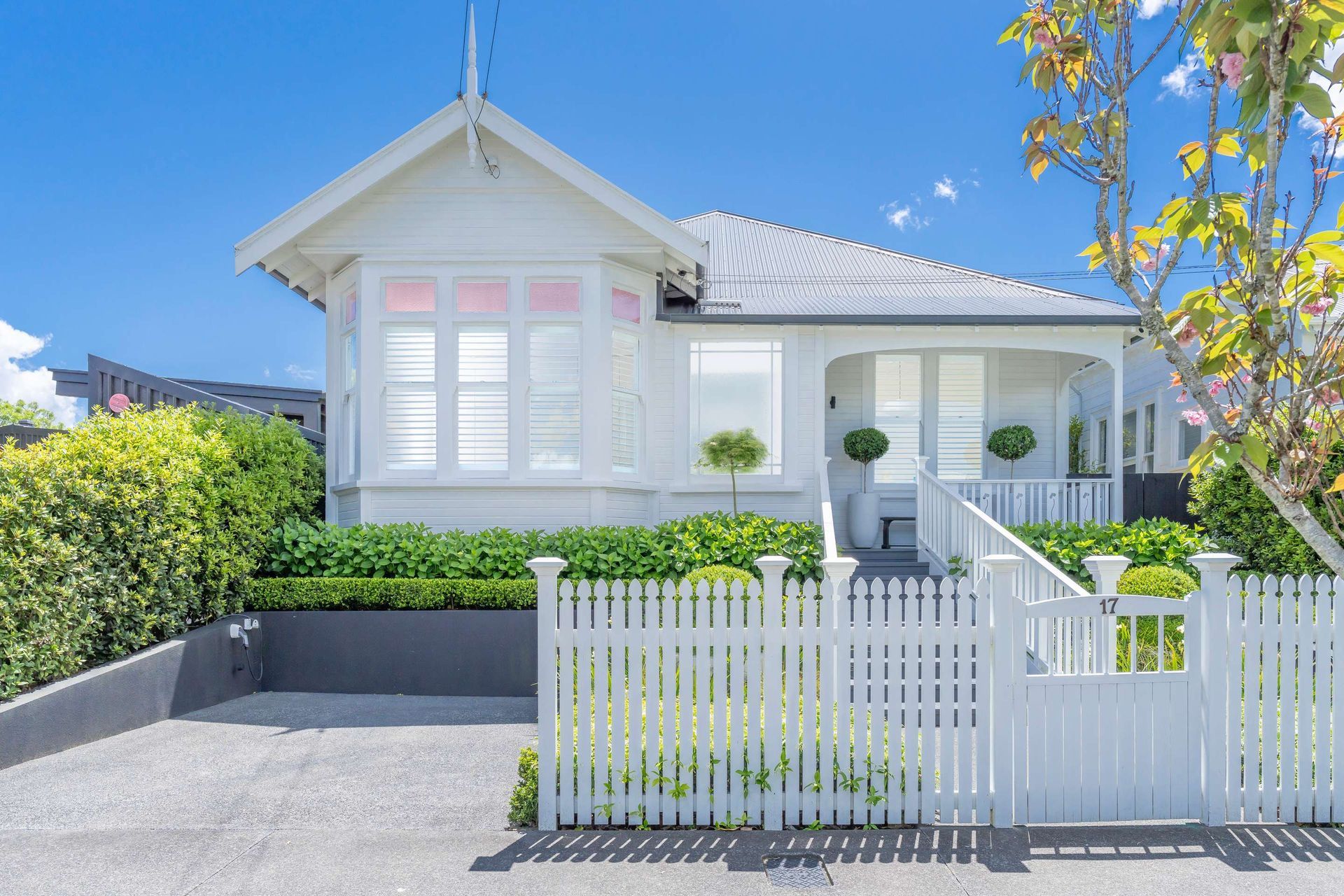 A white house with a white picket fence in front of it.
