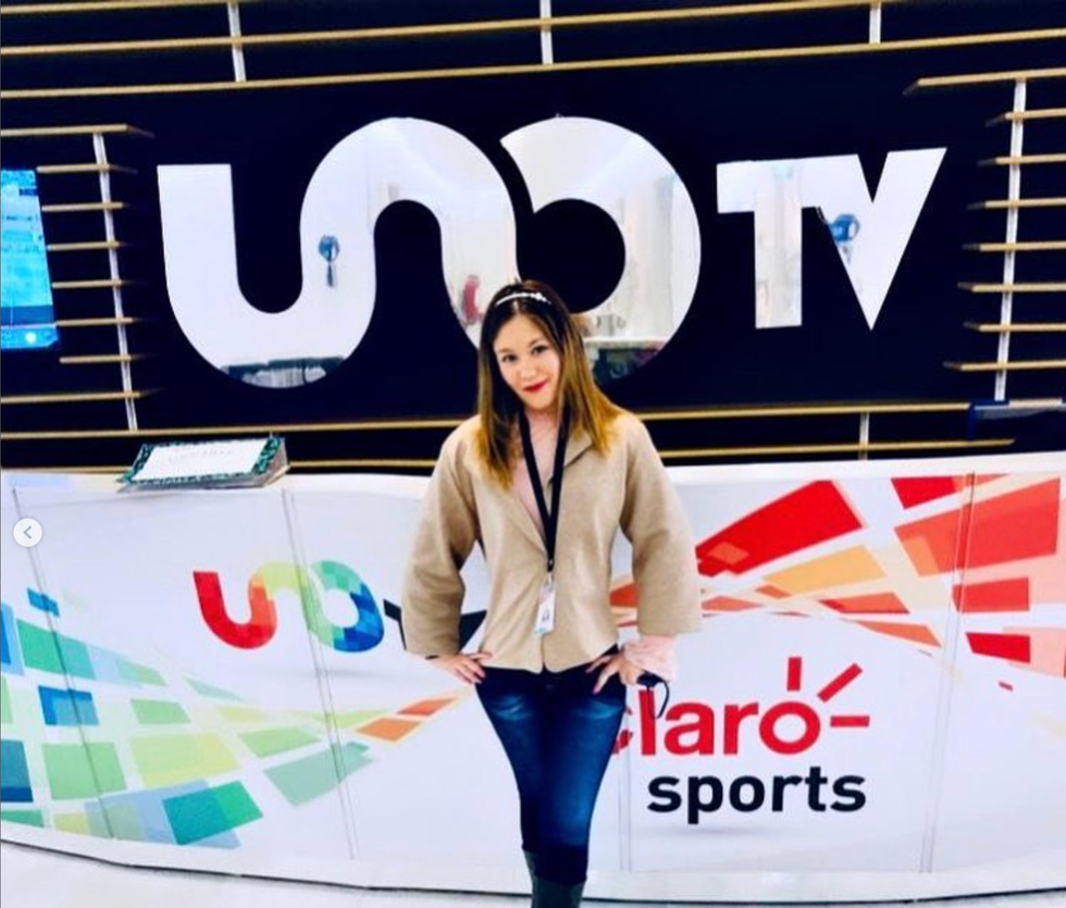 Mujer parada frente al logo de