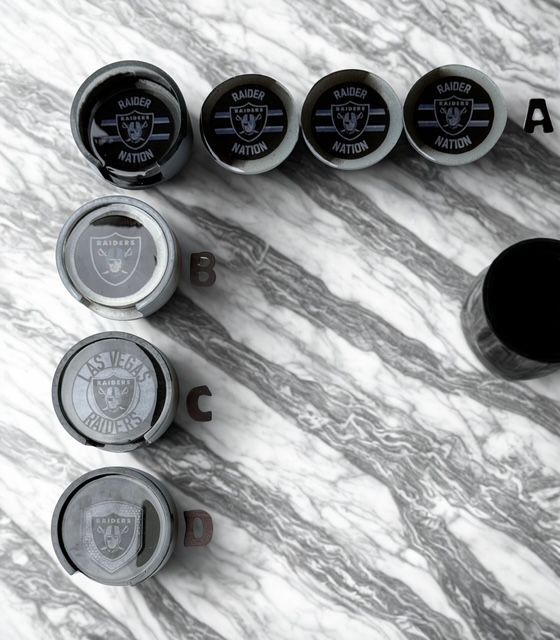 Several raiders bottle caps are lined up on a marble surface