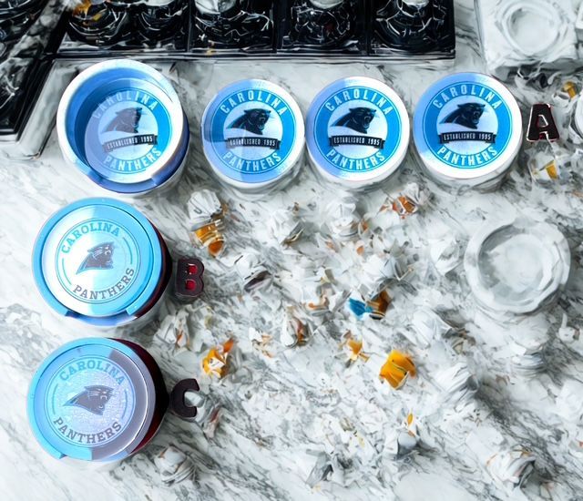 Carolina Panthers-themed items: containers with team logo arranged on a marble surface.