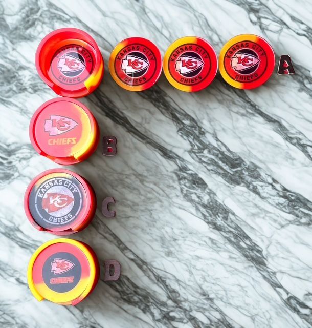 A selection of red and yellow Kansas City Chiefs logo containers on a marble surface, labeled A-D.