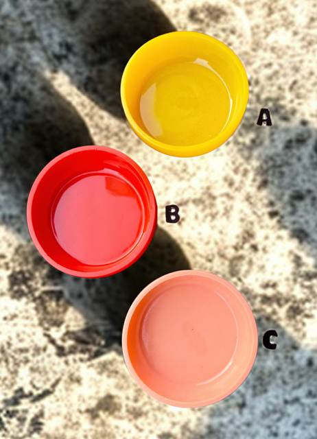 Three colorful bowls, yellow (A), red (B), and peach (C), on a textured surface.