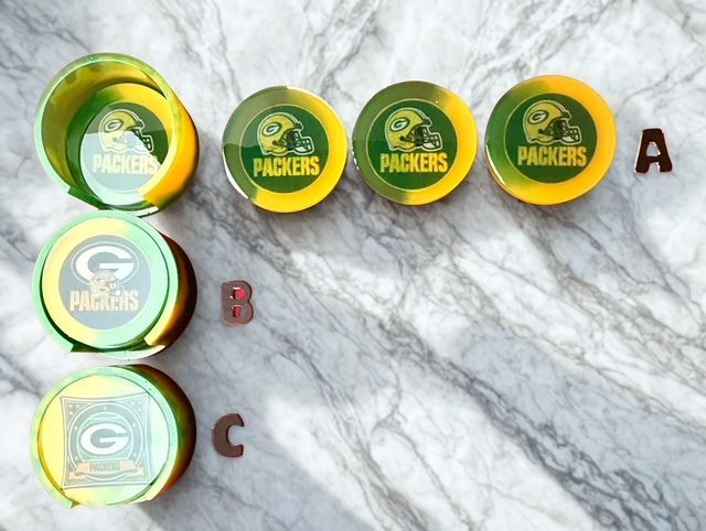 Green Bay Packers coasters in various designs, on a marble surface.
