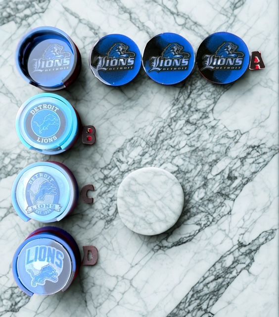 Detroit Lions coasters on a marbled surface. Blue, gray, and white colors.