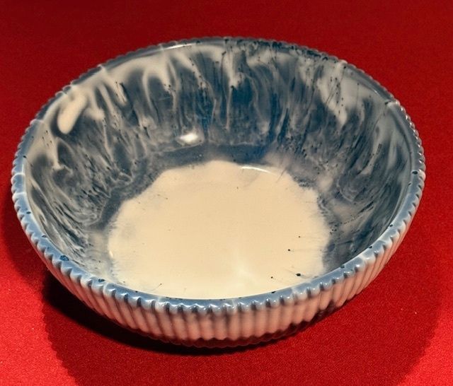 A blue and white bowl with a white liquid in it