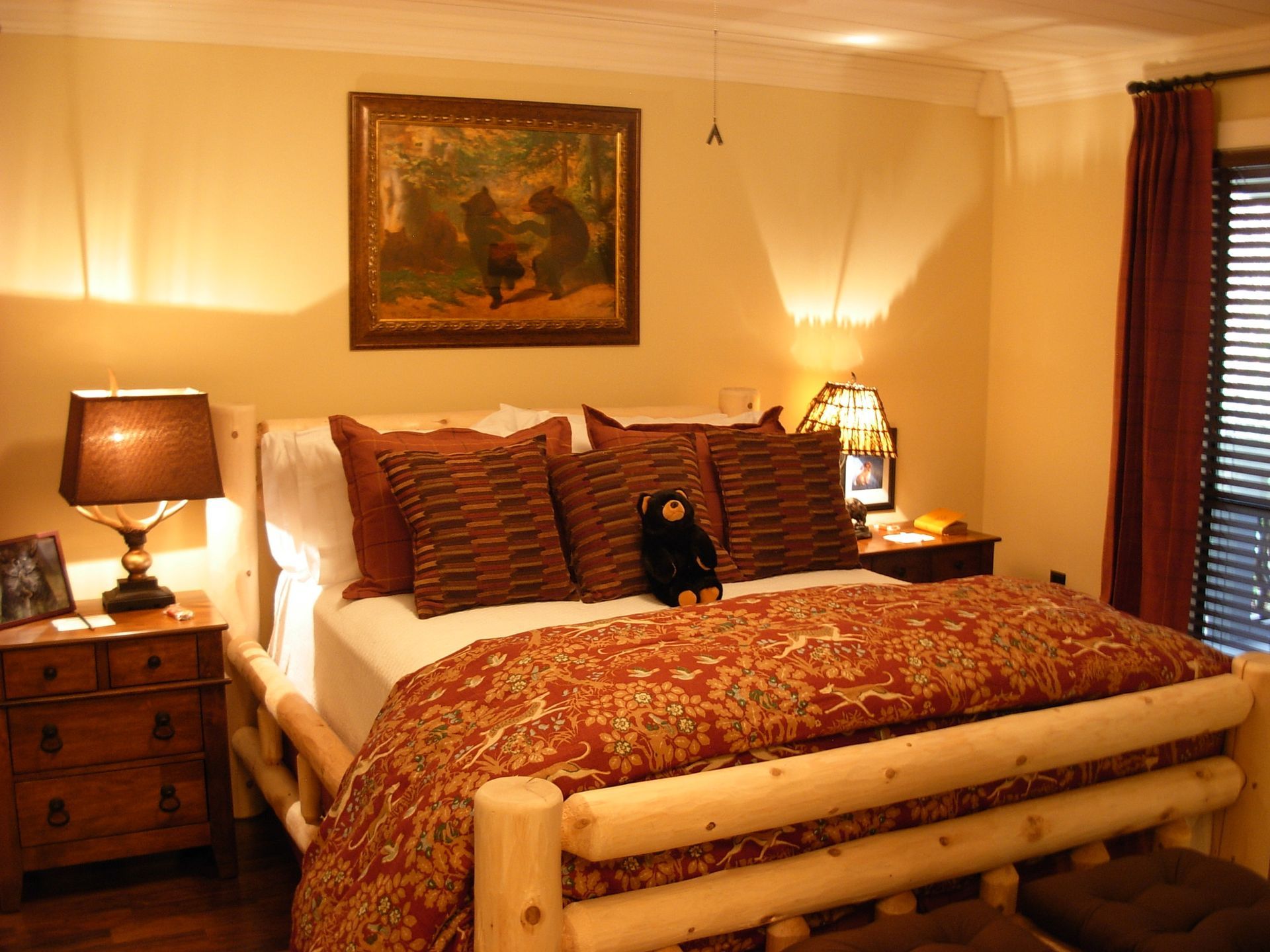 A bedroom with a log bed and a painting on the wall