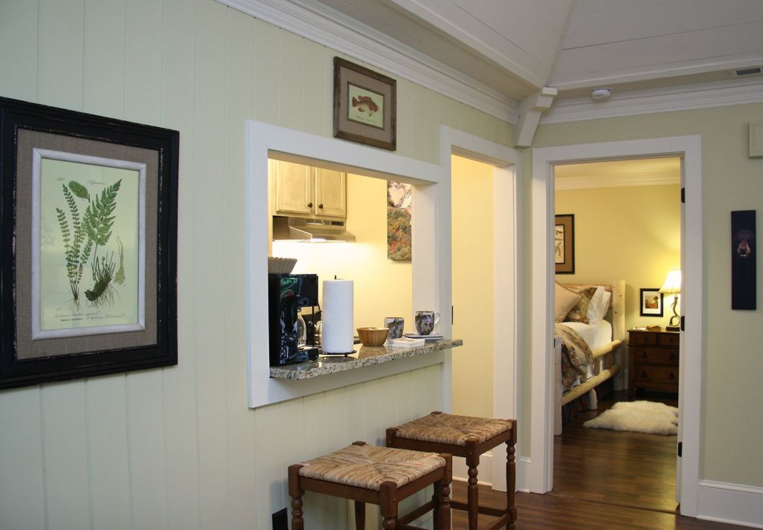 A kitchen with a counter and stools and a picture on the wall.