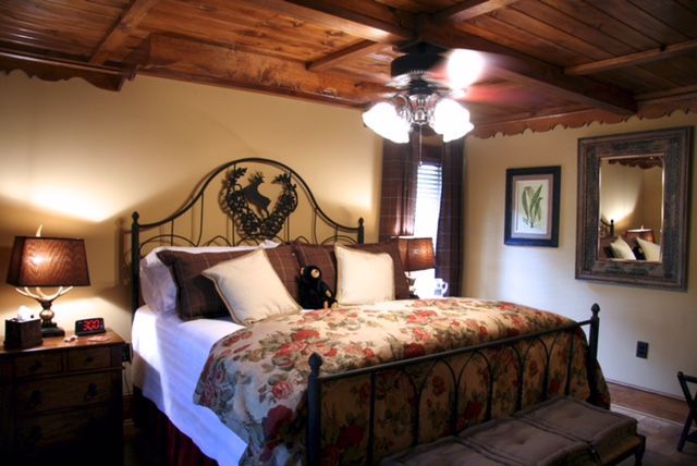 A bedroom with a large bed and a ceiling fan