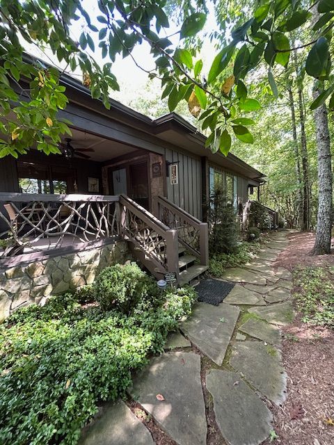 A house in the middle of a forest with a stone walkway leading to it.
