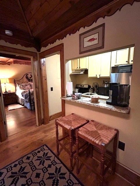 A kitchen with stools and a picture of a fish on the wall