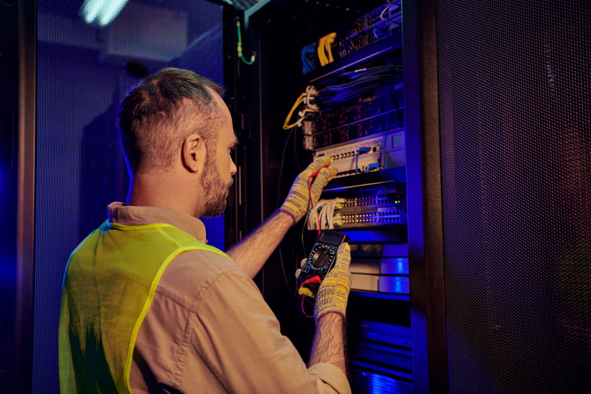 A man is working on a server in a data center.