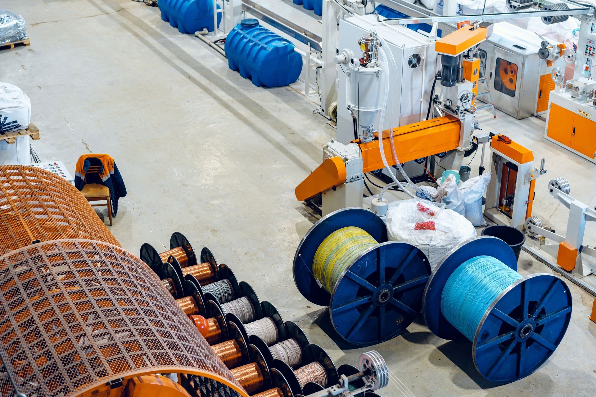 A bunch of spools of wire are in a factory