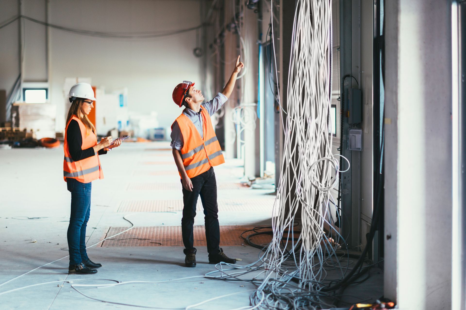 A man and a woman are standing in a building under construction.