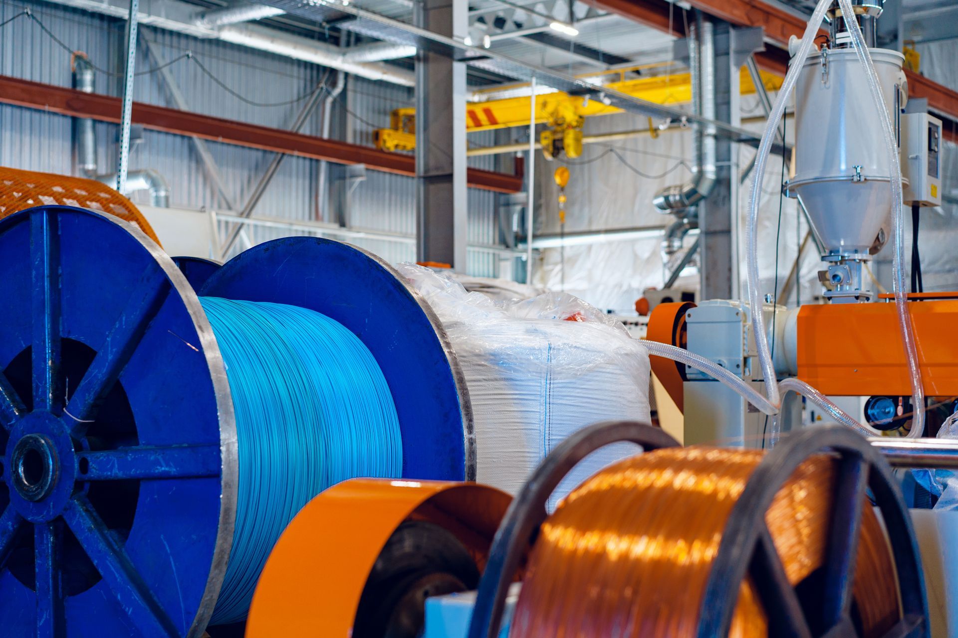 There are many spools of wire in a factory.