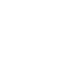 A large, brown, oval-shaped loaf of rustic bread with a scored, flour-dusted crust sitting on a dark surface.