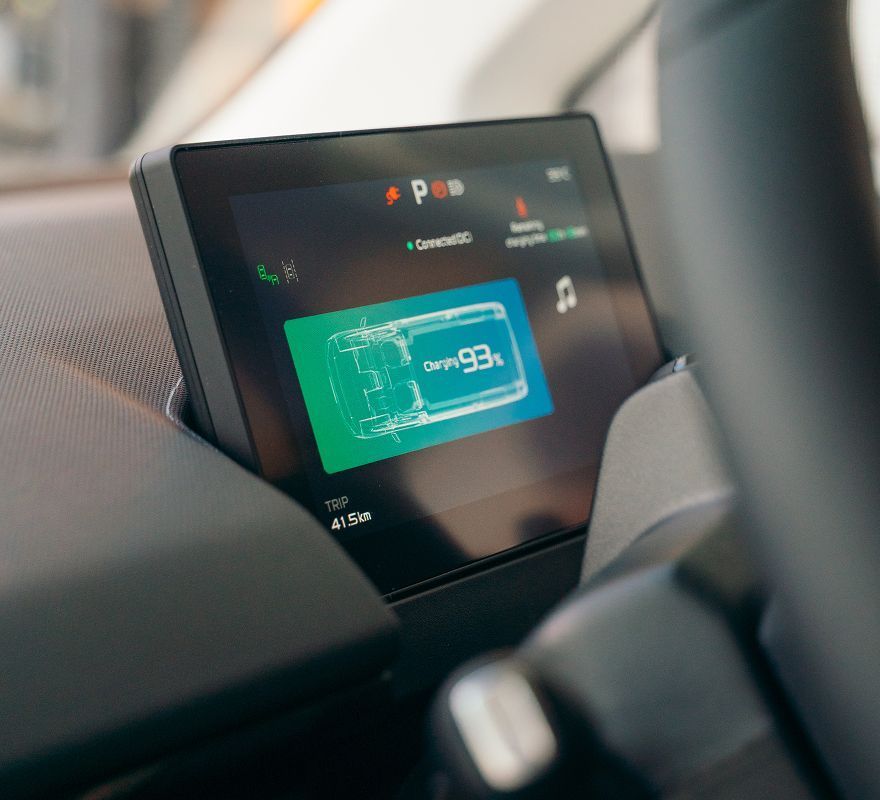 A car's digital dashboard screen showing a vehicle status graphic with a 93% charge level indicator.