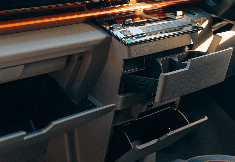 Modern car interior dashboard featuring a touchscreen, center console, and multiple open storage compartments.