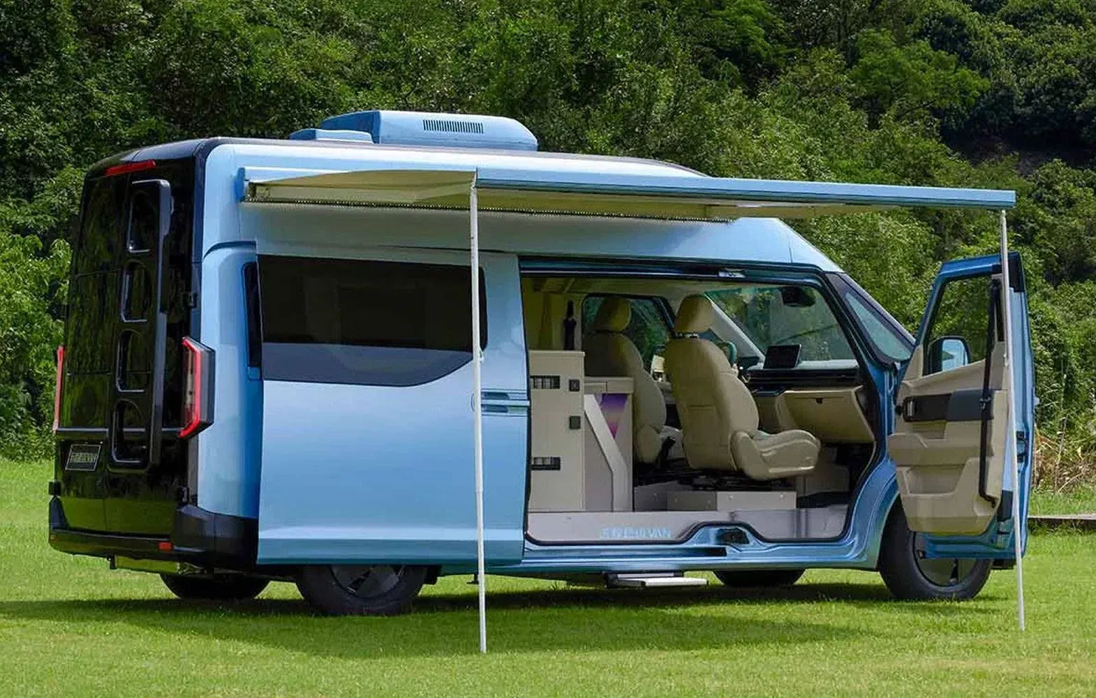 A light blue camper van parked on a grassy field with its side door and awning open, revealing beige interior seats.