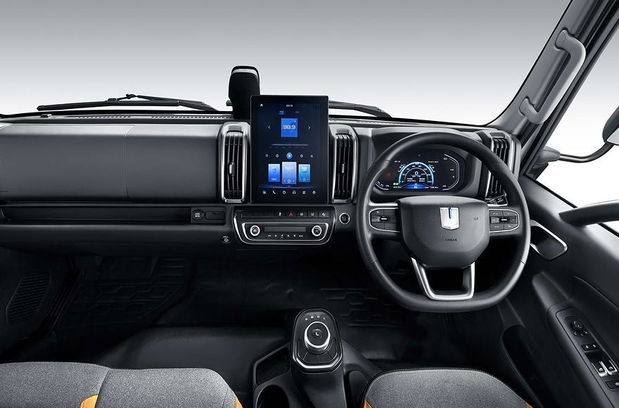 Modern vehicle interior featuring a prominent center touchscreen, digital instrument cluster, and a multi-function wheel.