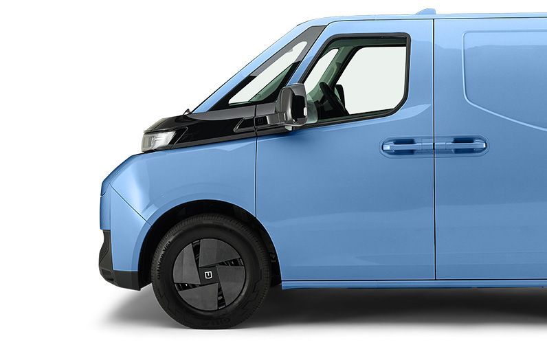 A side profile view of a light blue commercial delivery van with a black front section and dark wheel covers.