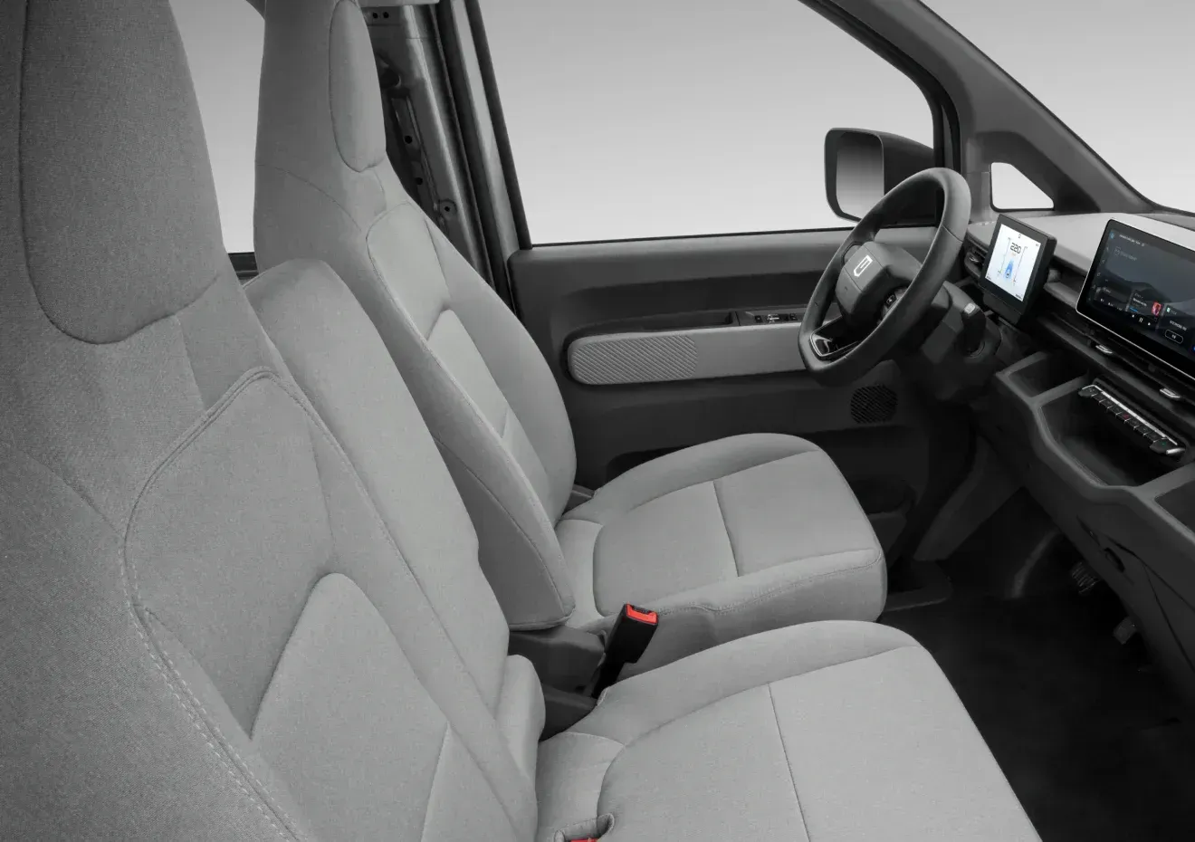 Interior view of a vehicle cabin with light grey fabric seats, a steering wheel, and dashboard screens.
