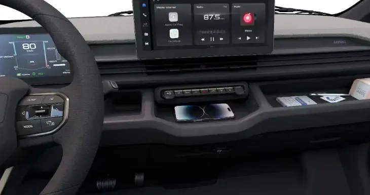 A car interior showing a digital dashboard, a central touchscreen infotainment system, and a phone charging on the console.