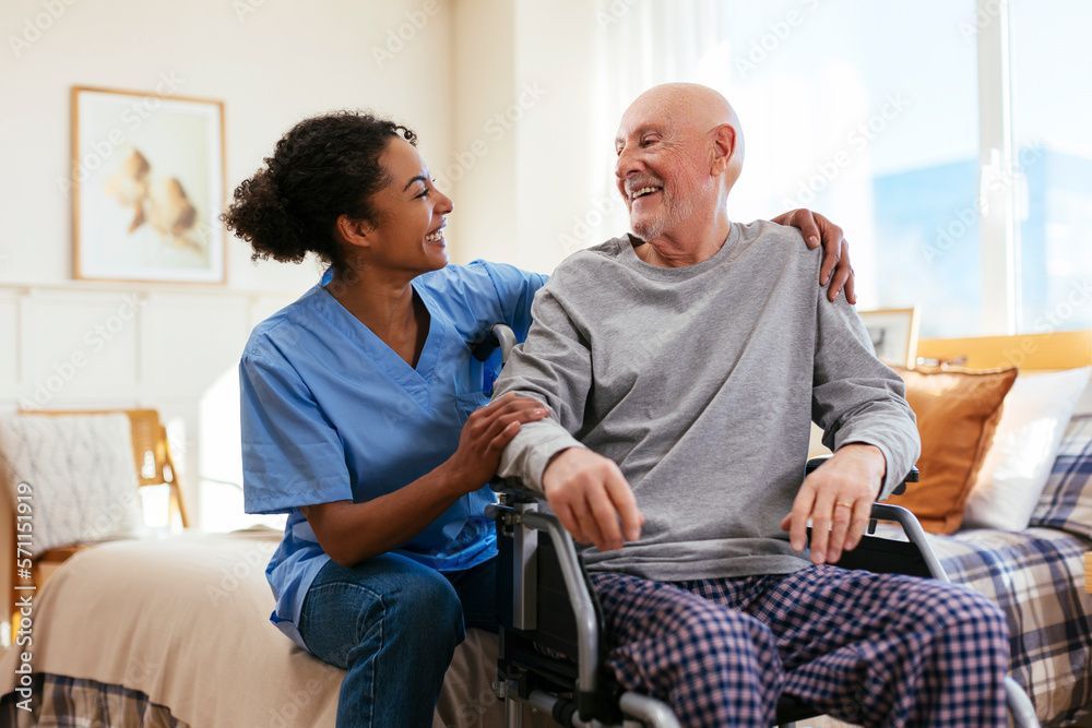A female orthopedist in dark blue scrubs checks the knee of a patient in a hospital ward.