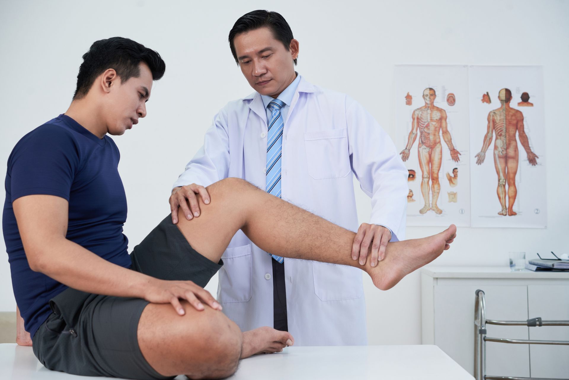 Athletic Injury Physician assessing young athlete with leg trauma.
