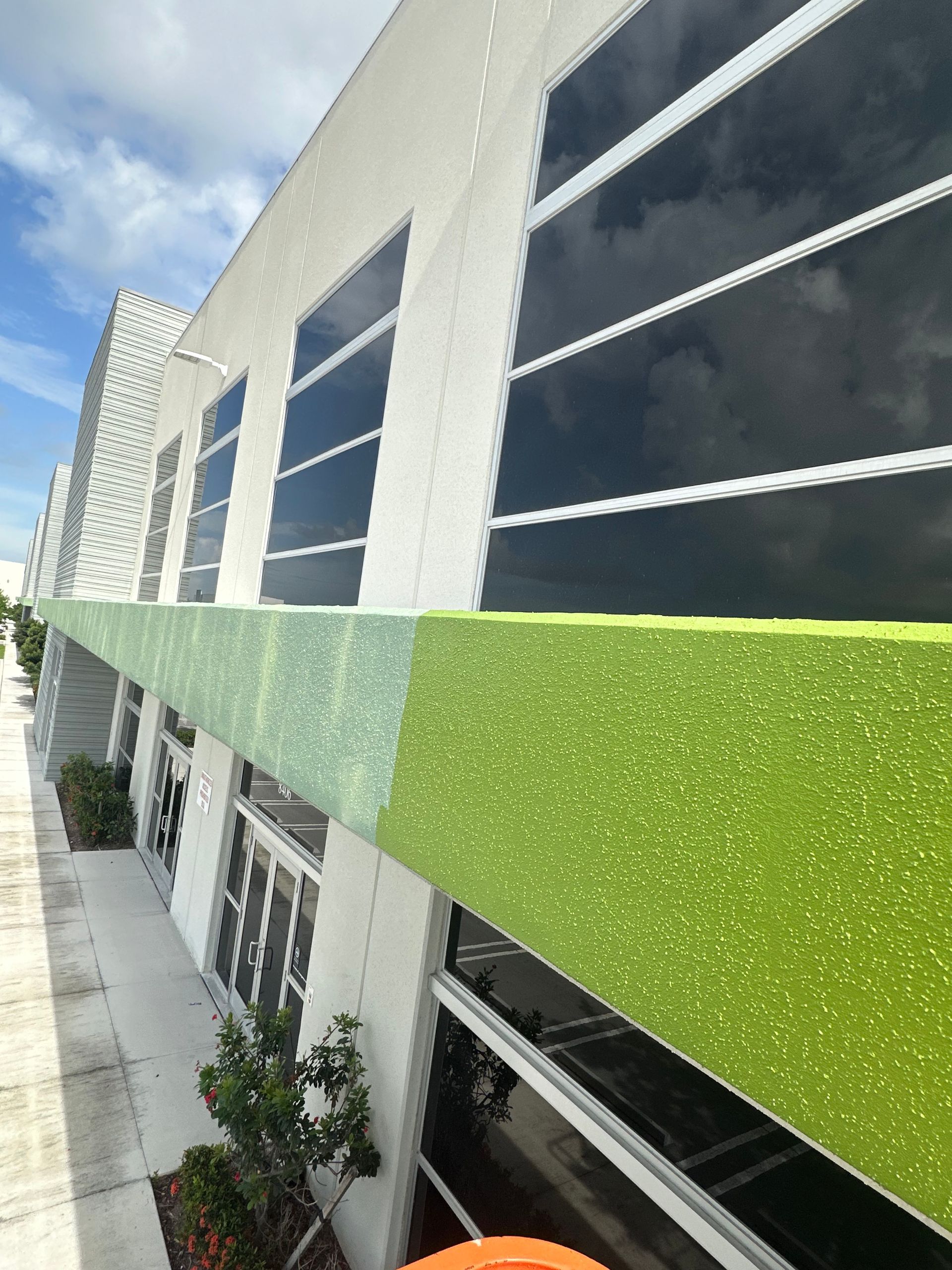 Bathroom with a floating sink, gold faucet, and textured gray and white walls.