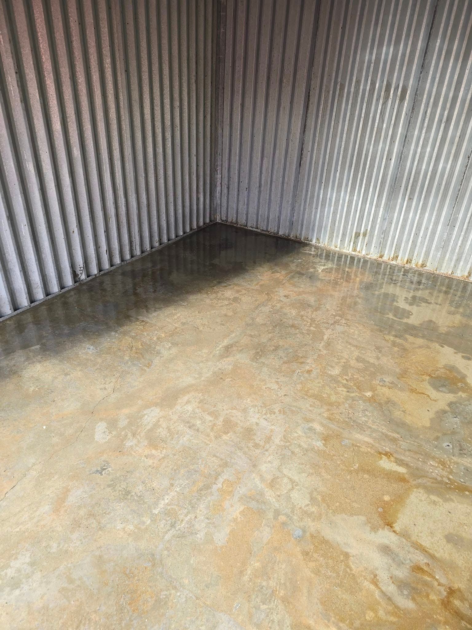 A room with a concrete floor and a metal wall.