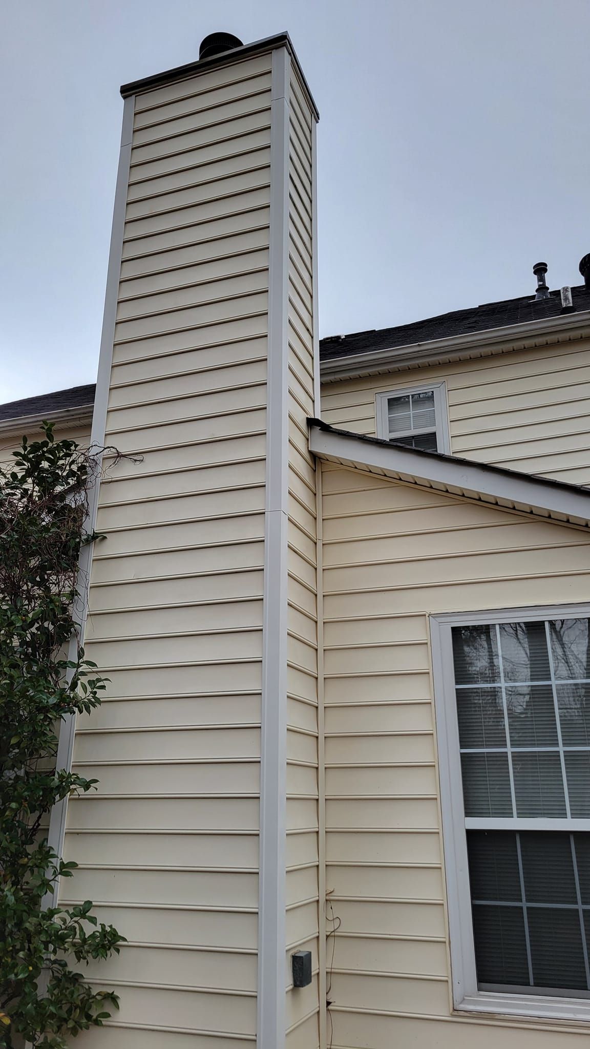 A white house with a chimney on the side of it.