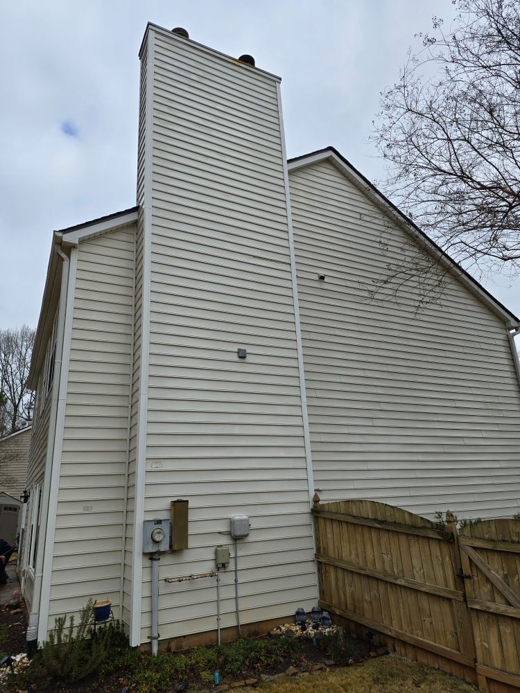 A large white house with a chimney on the side of it.