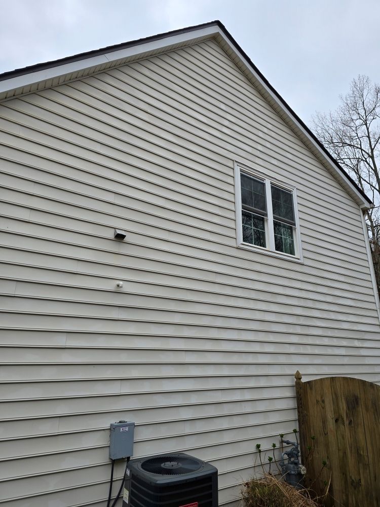 A white house with a black air conditioner on the side of it.