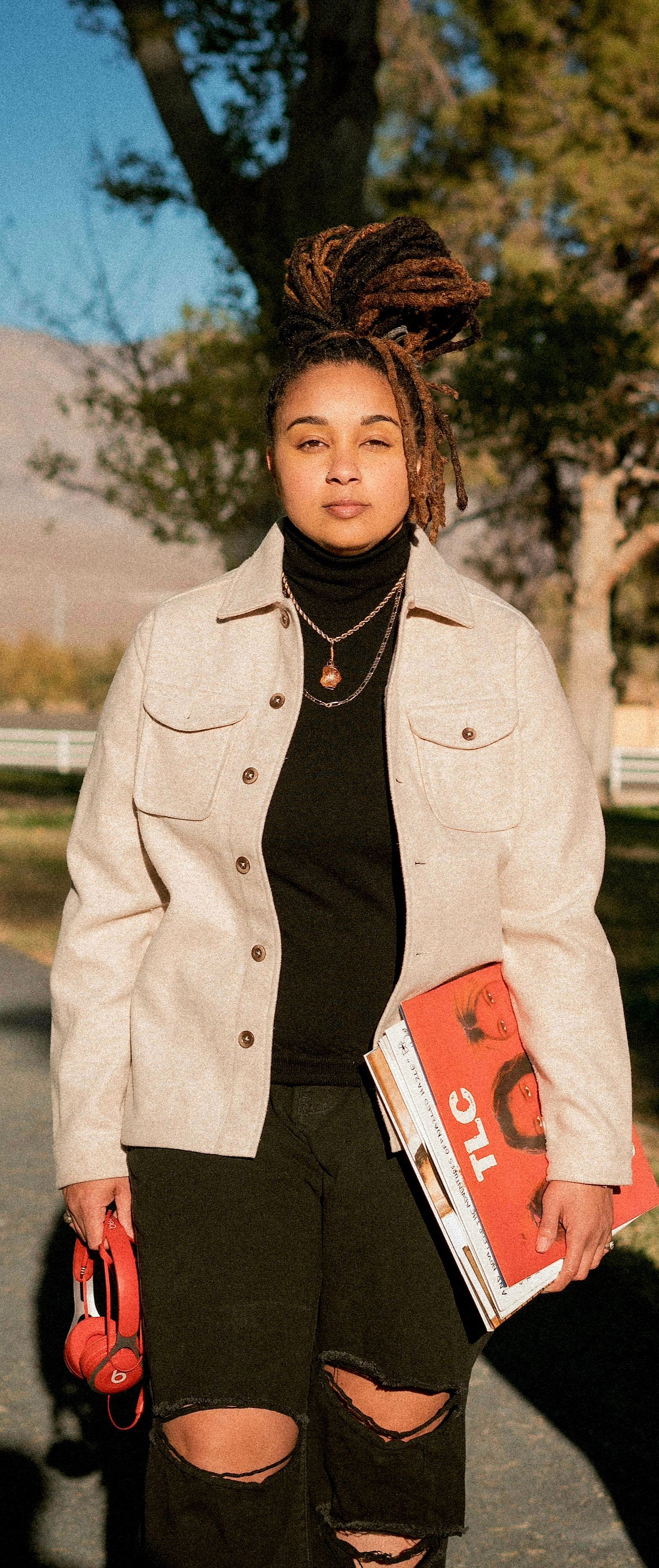 A woman is smiling for the camera while wearing a black jacket and white shirt.