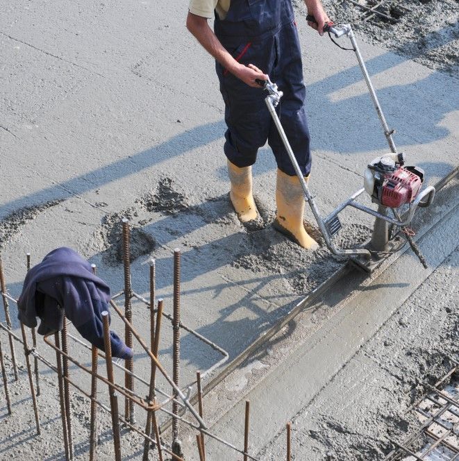 A Man Is Using A Machine To Mix Concrete — Neil Stafford Concreting In Mareeba, QLD